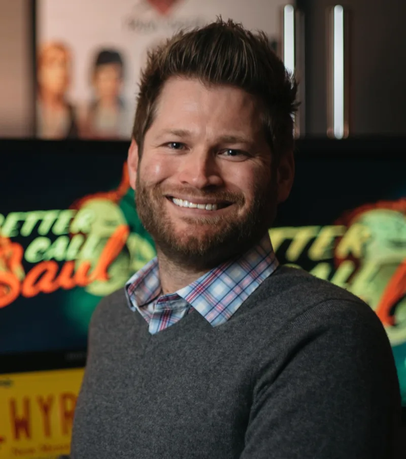 Chris McCaleb smiling in front of a Better Call Saul backdrop