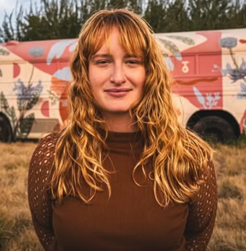 Heather Zink standing in front of a vintage camper